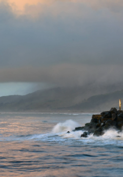 Waves crashing against rocks on a stormy day