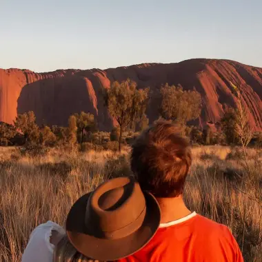 Couple looking at Uluru (Ayers Rock) located in the Red Centre, Northern Territory, Australia