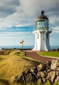 View of Cape Reinga Lighthouse on a cloudy day and Tasman Sea in the background