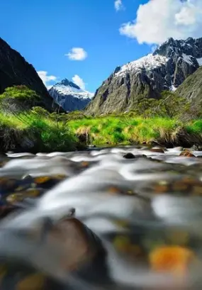 A stunning alpine stream with snow-capped mountains in Milford.