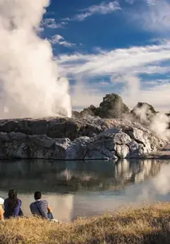 Steam rising from rocks by the lake in Rotorua