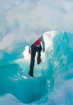 Person walking through Fox Glacier Ice Cave