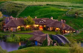 Hobbit house at dusk with the lights on