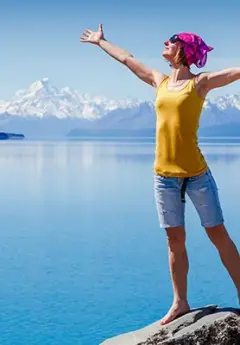 Woman enjoying a sunny day by Lake Pukaki and Mt Cook National Park in the background