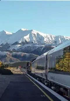 Tranzalpine scenic train and mountains in the background