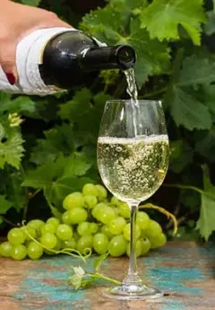 Glass of white wine and green grapes