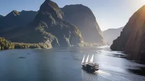 Boat cruising through Milford Sound