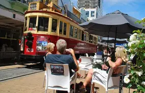 People relaxing and watching the tram in Christchurch