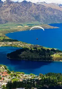 Paraglider flying over Queenstown