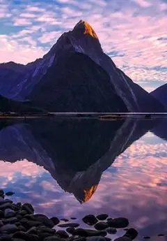 Milford Sound and a mountain reflection in the water during sunset