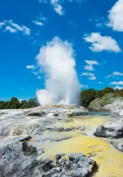 A geyser blasts steaming water high into the sky.