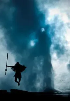 Maori performer jumping in front of geothermal geyser