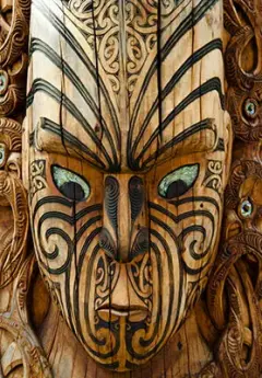 A wooden Maori carving in Rotorua of a face with eyes made from Paua