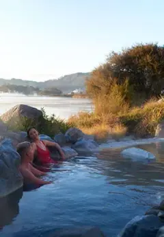 A couple relaxing in a Polynesian Spa, Rotoroa