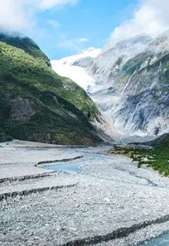 View of Franz Josef Glacier surrounded by lush forests