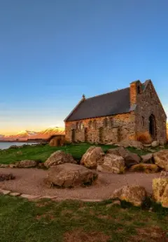 Old brick Church in front of mountains at sunset